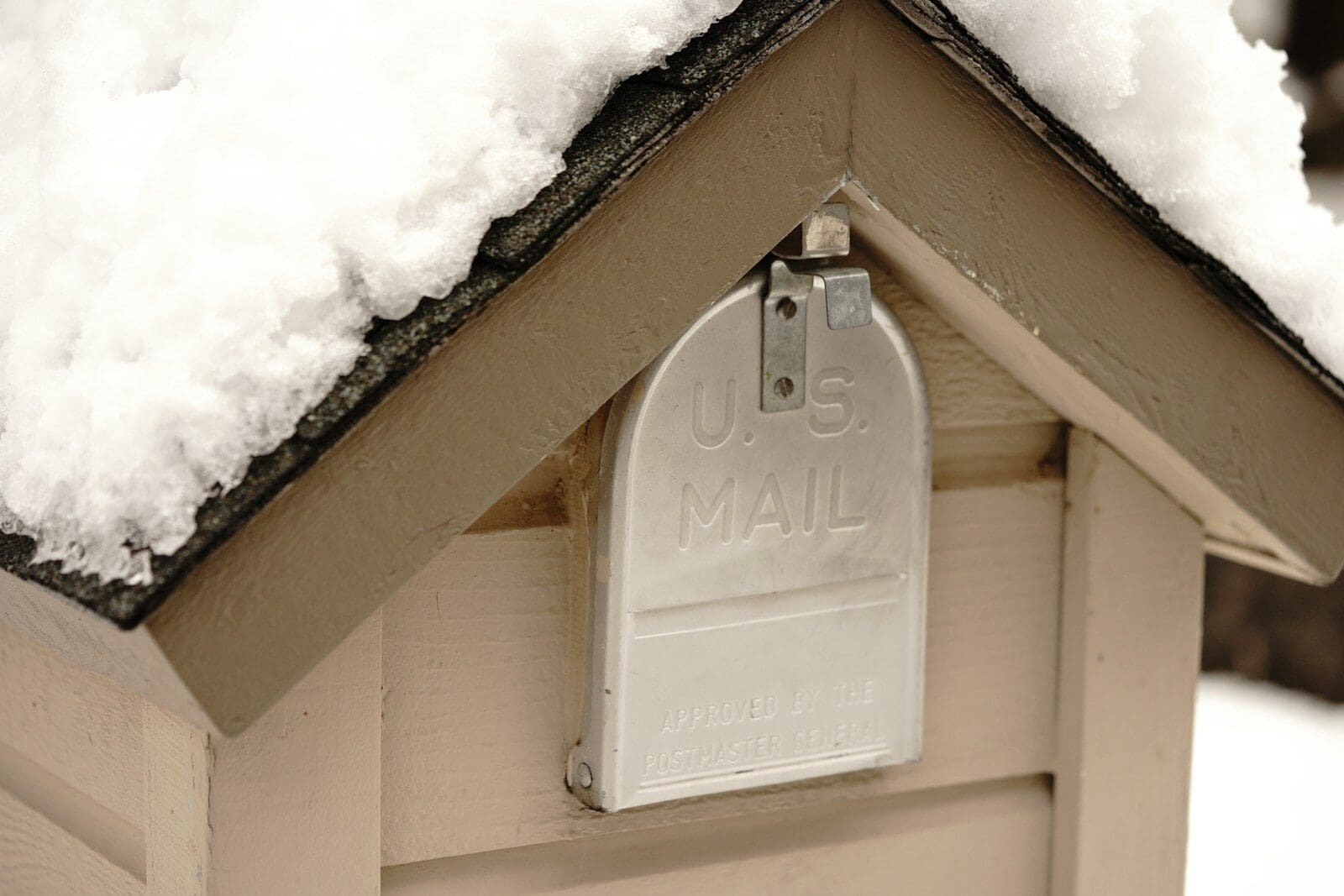 A snowy mailbox with "us mail" visible on the flap.
