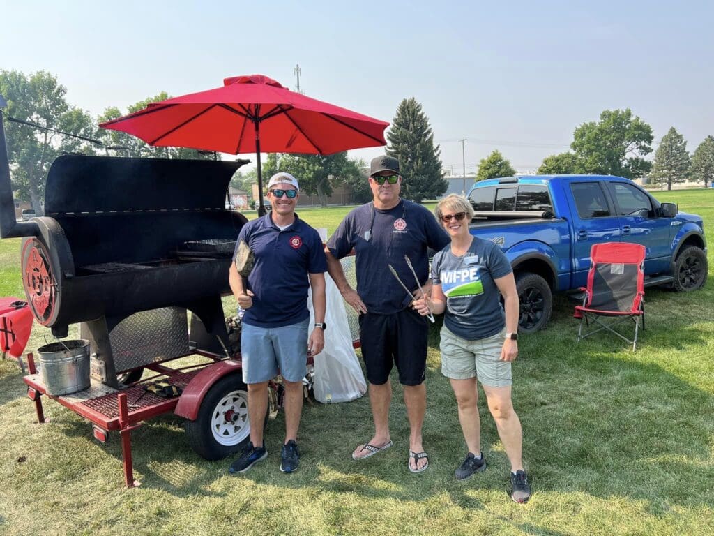 Denise Baum with firefighters at a BBQ